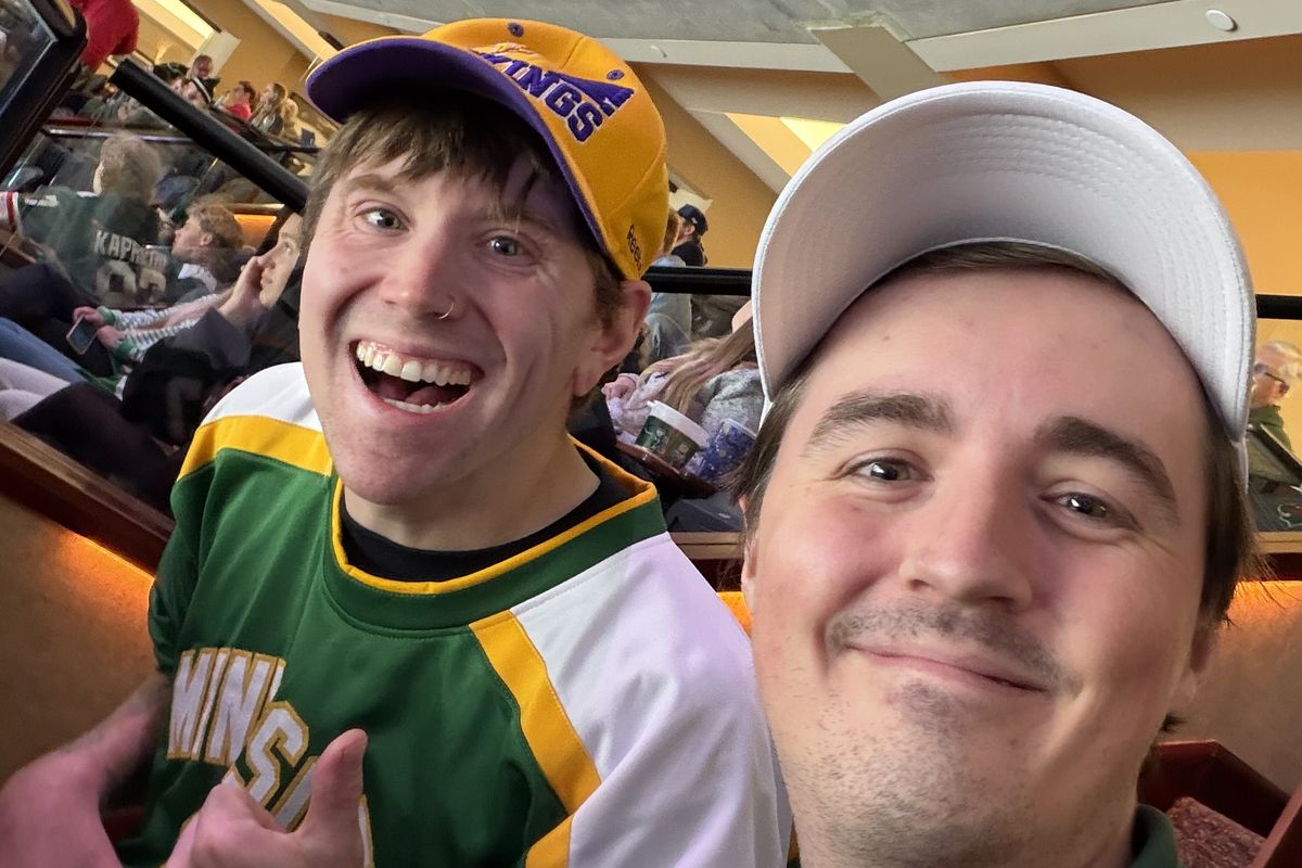 Two friends grinning in a selfie at the game